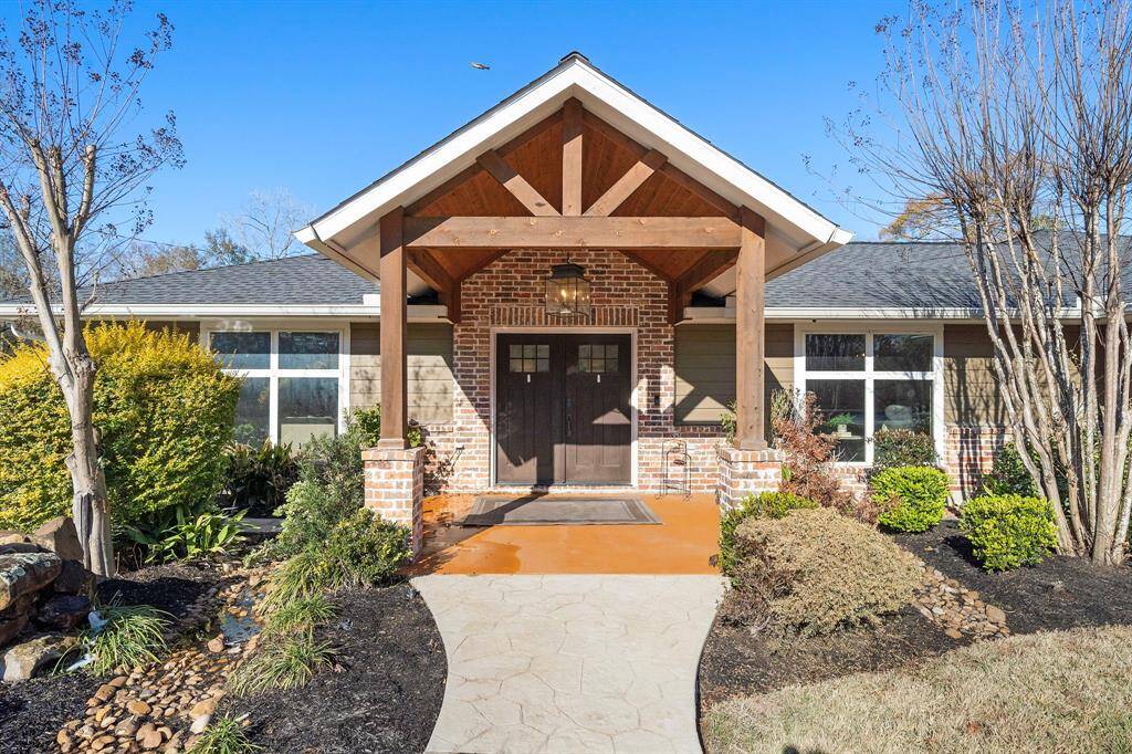 Beautiful grand entryway with a vaulted ceiling, double doors, and a chandelier.