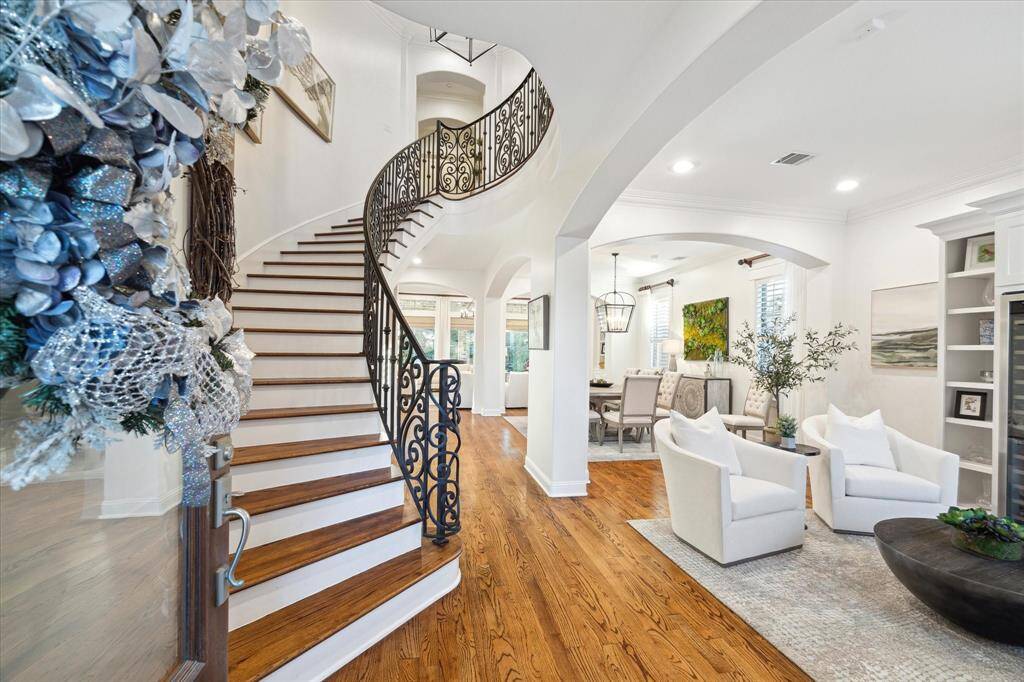 Step into an opulent foyer that sets the tone for the entire home. With soaring ceilings and gleaming wood floors, this grand entrance is a prelude to the luxury that awaits.