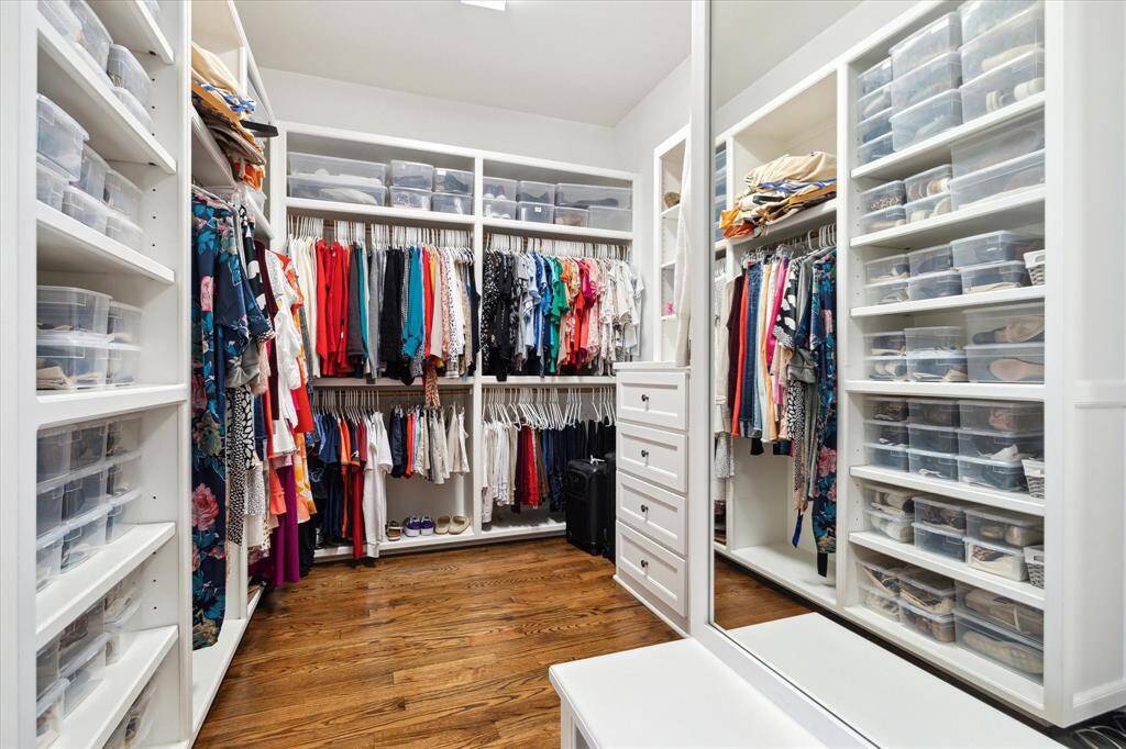 Owners closet is complete with built-in dressers, adjustable shelving and bench with additional storage.