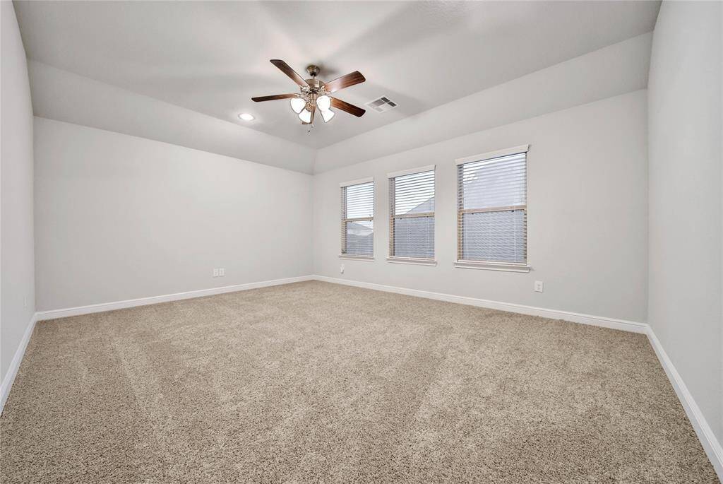 Extra bedroom that is spacious with neutral walls leads into a jack and Jill style bathroom.
