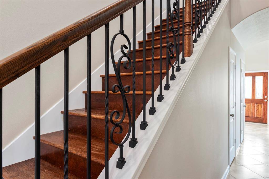 Even the staircase exudes elegance, featuring a harmonious blend of neutral hues and exquisitely crafted designer iron spindles.