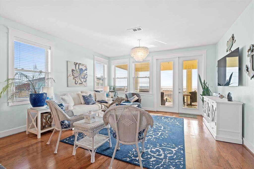 This large living room has WATER VIEWS, a shell chandelier, coastal chic blue and white furnishings. All tv's and electronics stay!