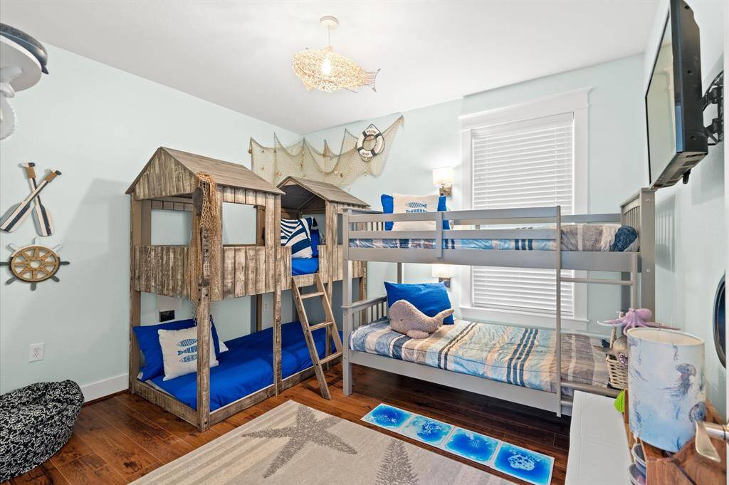 FUN bunk room comes fully furnished including the bunks, tv and decor! Notice the fabulous fish chandelier overhead!