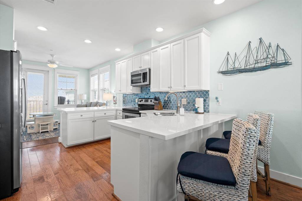 Beautiful coastal blue and nautical white kitchen with new quartz counter tops and a azure blue backsplash! Cabinets are stocked and ready for your kitchen creations!