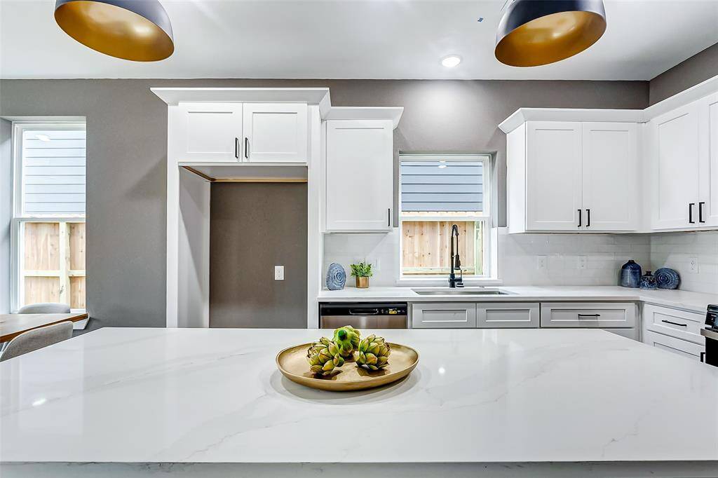 Featuring a stunning quartz island and large windows, this kitchen is bathed in natural light.