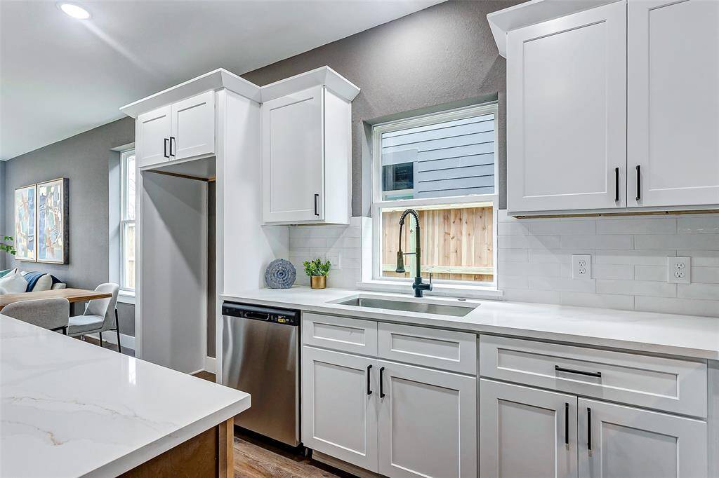 Enjoy the convenience of a double-door fridge, dedicated dishwasher space, and a bright sink area with a large window.