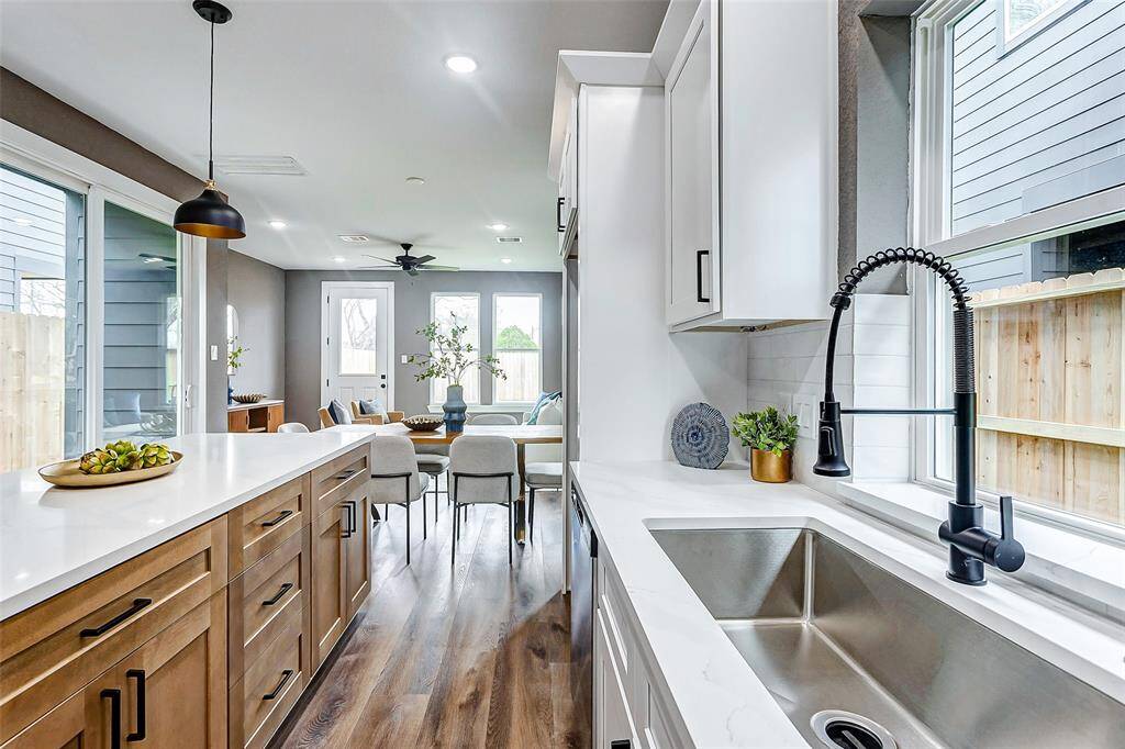 Experience the perfect blend of natural warmth and modern design with rich wooden cabinets and matching floors, seamlessly flowing into the living area.