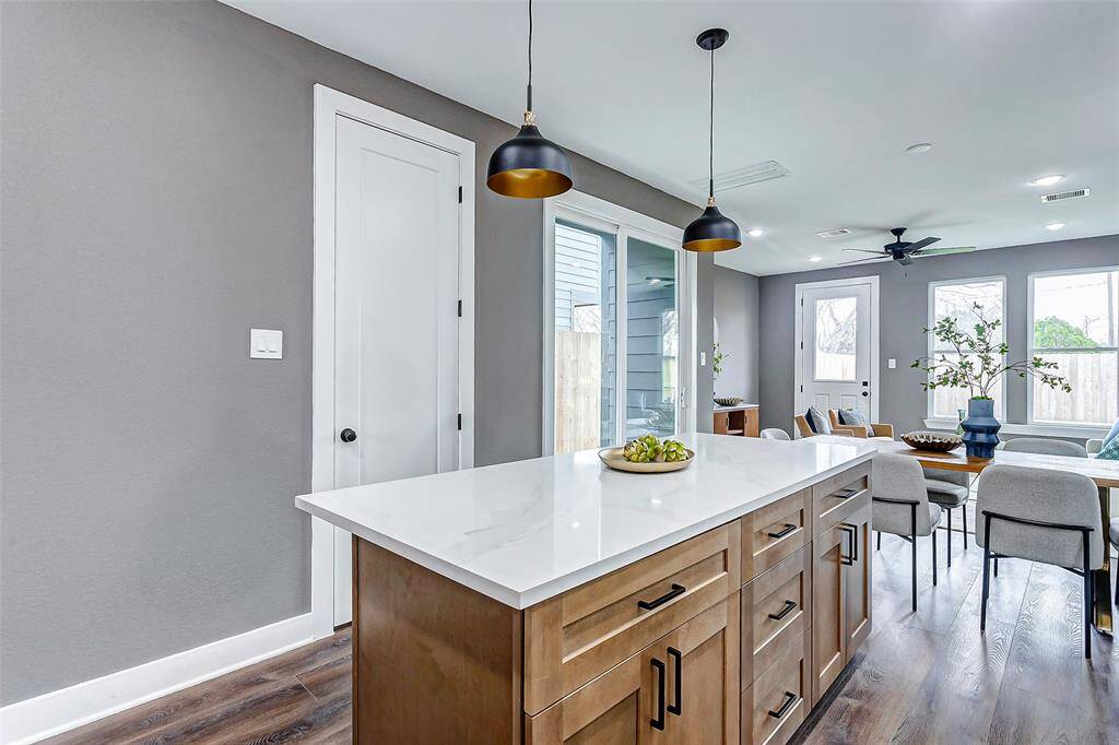 This kitchen island, paired with warm wood tones and ample storage, anchors the open layout, blending practicality with modern elegance.