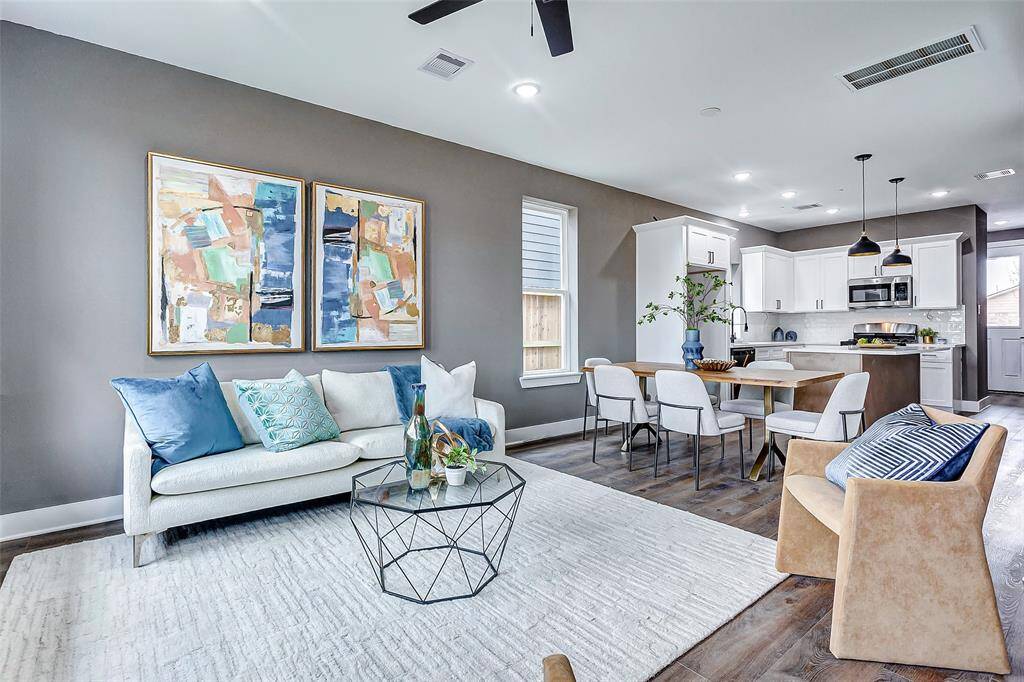 Warm, inviting tones seamlessly connect the living room, dining area, and kitchen, creating a cohesive and welcoming space.