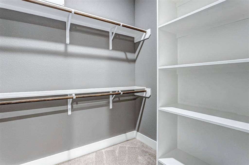 Expansive walk-in closet with dedicated shelving for shoes and clothing.