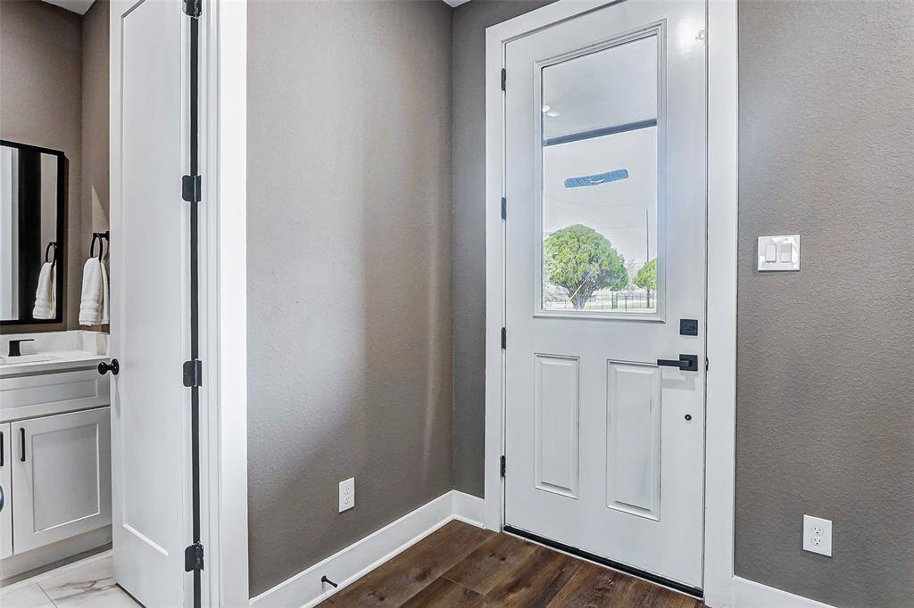 Inviting entrance with a white door that enhances natural light and spaciousness.