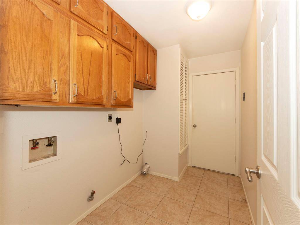 Utility room with additional storage and door to garage.