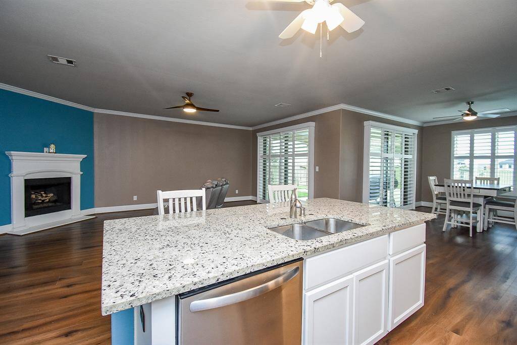 Enjoy panoramic views of a serene backyard, sparkling pool, and tranquil lake from the heart of your gourmet kitchen. Two sets of large sliders with plantation shutters open to the covered patio.