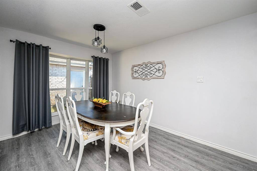 Dining area with vinyl plank floors, and pendant lighting.