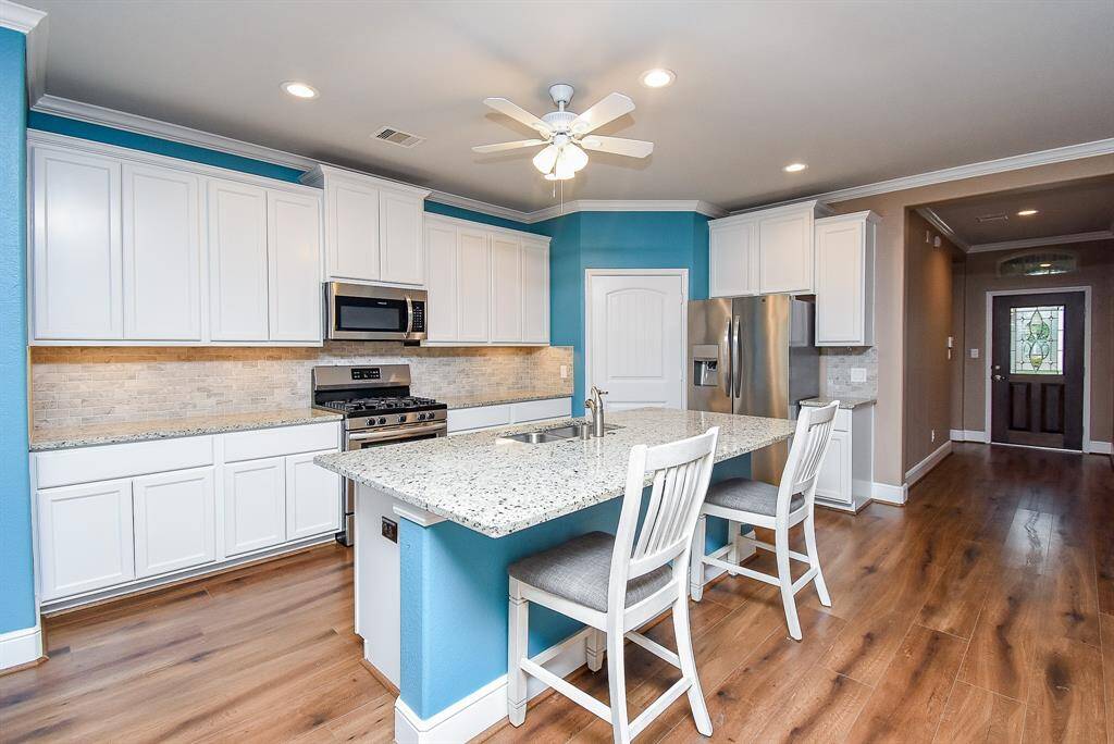 Discover culinary delight in a gourmet kitchen, boasting a spacious island with undermount sink, a generous walk-in pantry, and plenty of cabinetry.