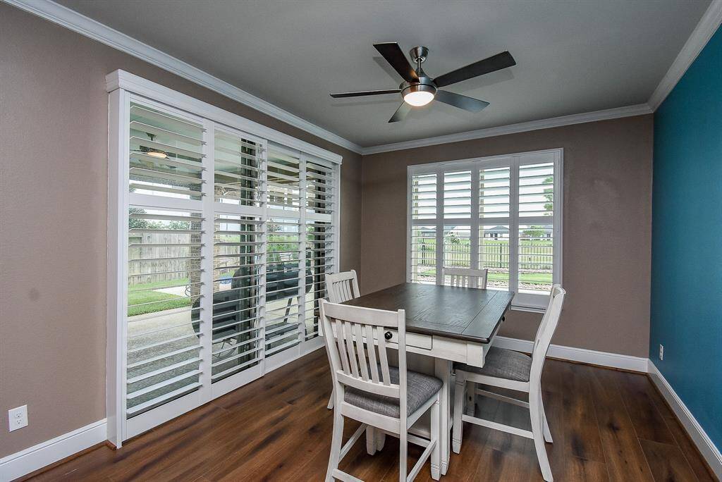 Seamlessly transition from the elegant dining room to the serene covered porch through expansive sliding doors, accentuated by charming plantation shutters.