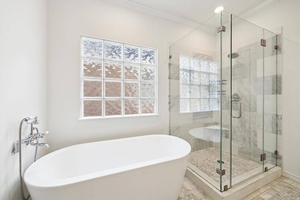 Soaking tub and walk-in shower in the primary bathroom.