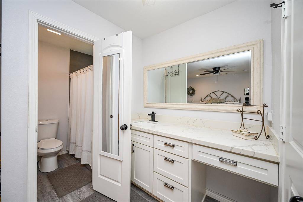 The master ensuite includes quartz countertops, a vanity area, and a framed mirror.