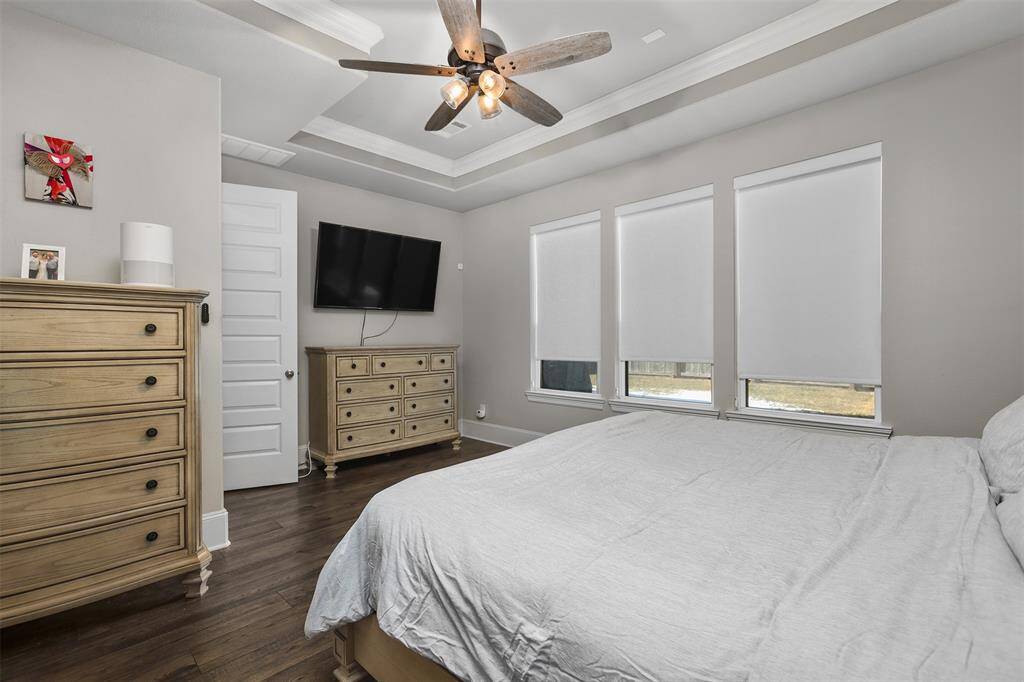 The trayed ceilings elevate the design in the master bedroom featuring laminate flooring and plenty of space.