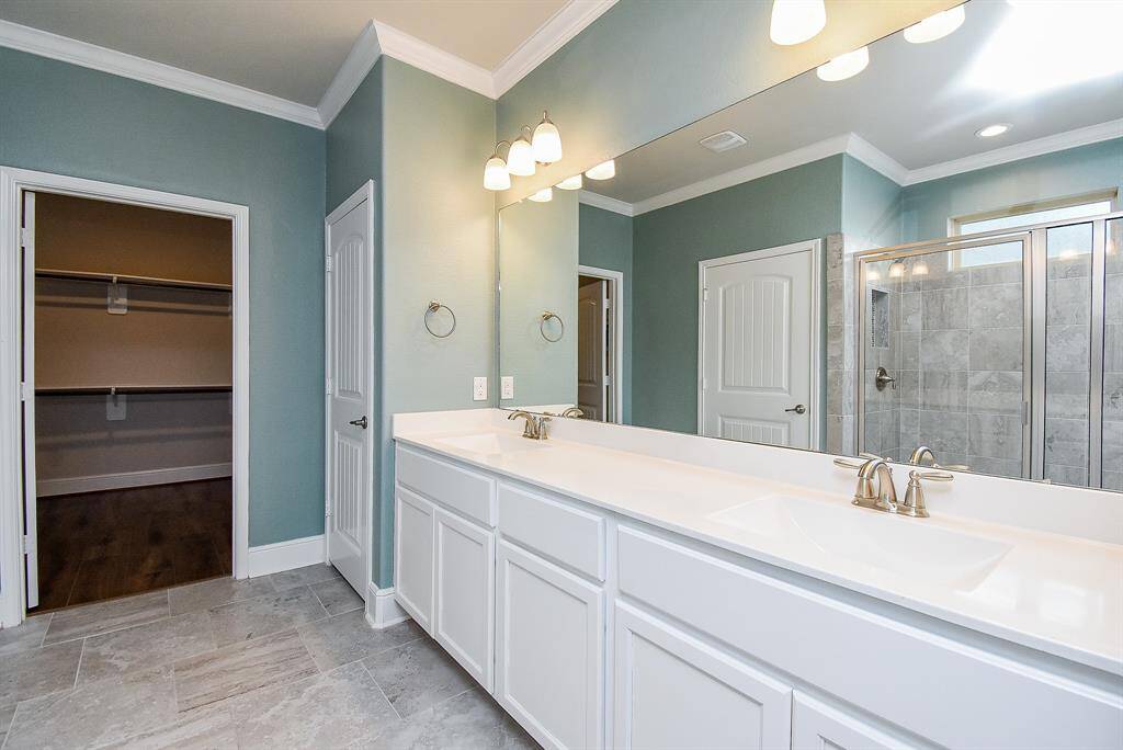 Indulge in the luxury of the primary ensuite, featuring a spacious walk-in glass shower with seating, undermount sinks, and a secluded water closet.
