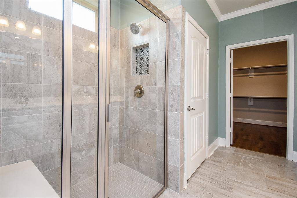 Experience spa-like luxury with the ensuite's expansive walk-in shower, complete with a built-in bench.