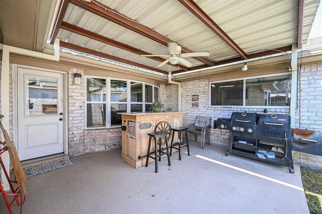 This covered patio features a high celing and a ceiling fan. Cook amazing food on your grill featuring gorgeous brick detailing.