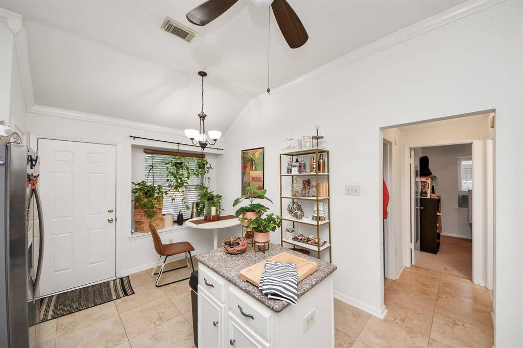 The kitchen has tile floors and a ceiling fan.