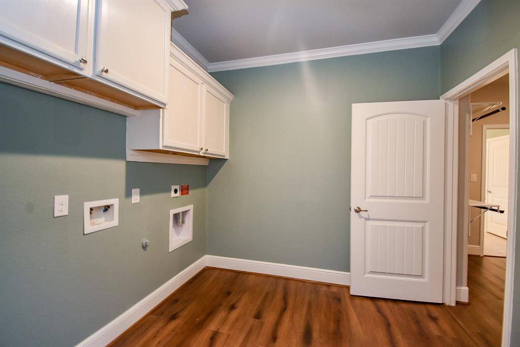 Effortlessly accessible from both the hallway and master suite, this laundry room boasts custom cabinetry and trim, complete with crown molding for a touch of luxury.