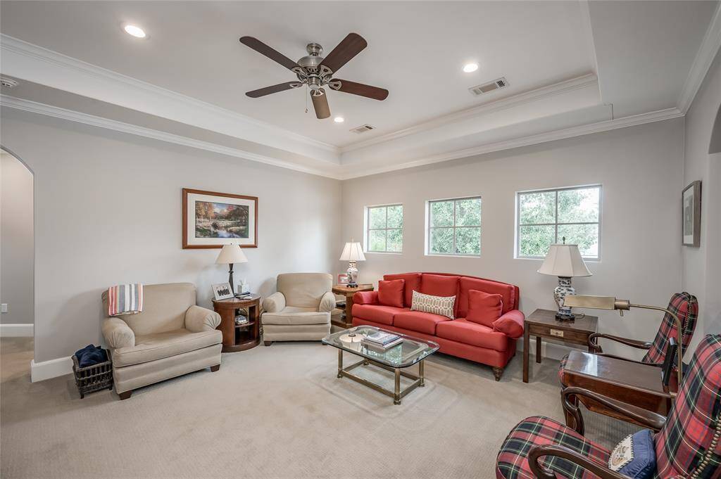 Second floor game room/den offers windows overlooking the side yard, tray ceiling, recessed lighting, and crown moulding. This flex space also functions well as a bunk room, home gym, playroom, or home office.