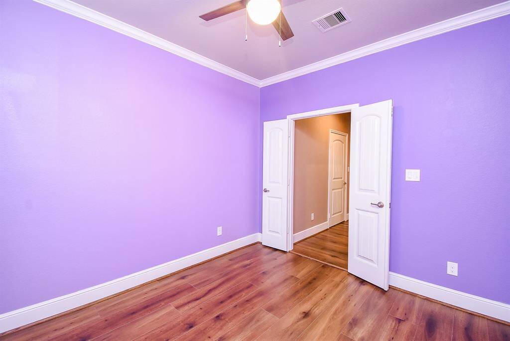 Discover the versatility of a front-facing study or flex room,  finished with durable LVP flooring, stylish plantation shutters, and custom trim and crown molding.