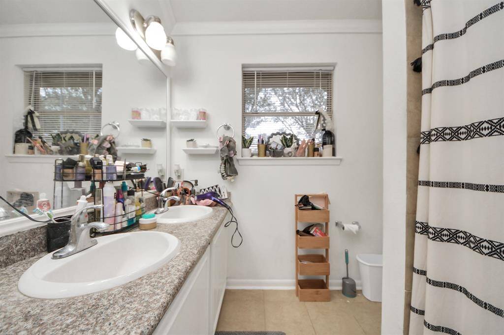 The primary bathroom features tile floors, dual sinks, and a tub and shower combo.