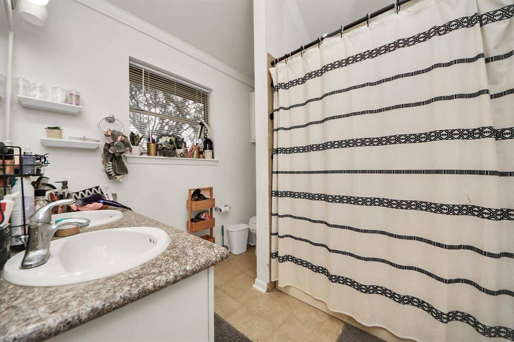 The primary bathroom features tile floors, dual sinks, and a tub and shower combo.