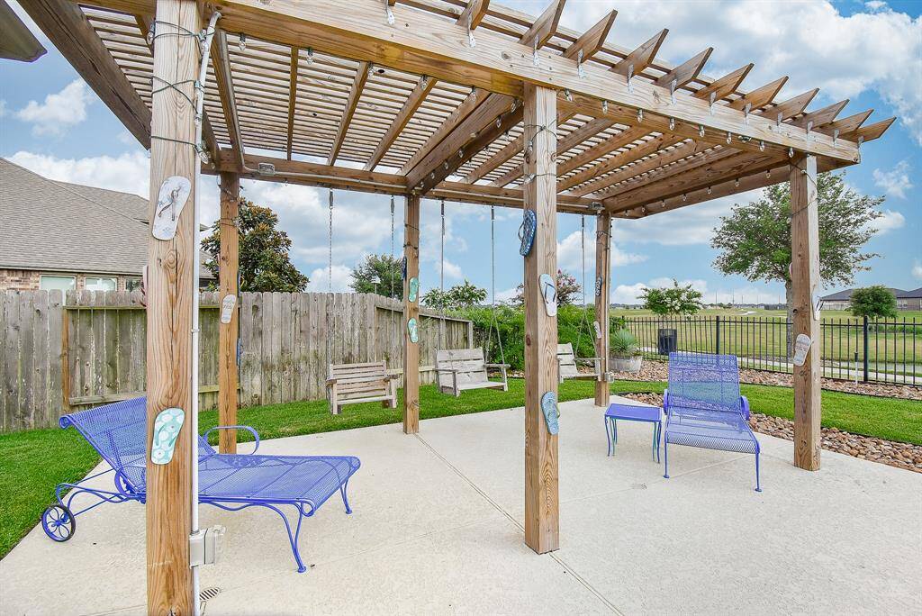 Enjoy the days and nights under this wood pergola overlooking the pool and lake.