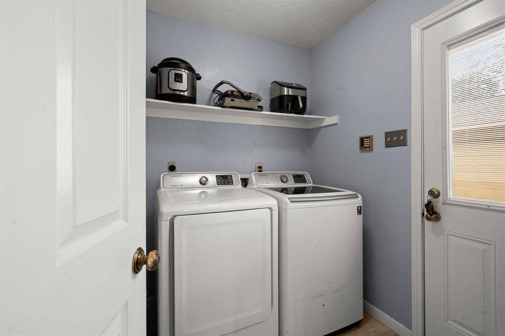 This immaculate laundry room is conveniently located by the kitchen and the walkway to the garage.