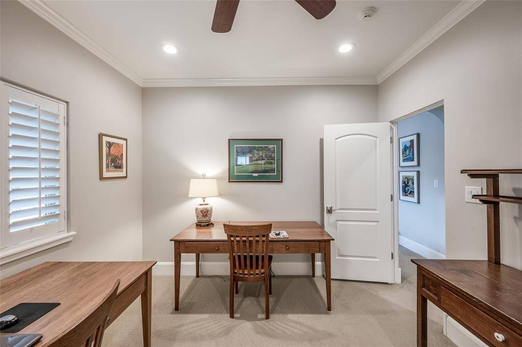 Secondary bedroom #2 currently being used as an office features windows with plantation shutters, en-suite bathroom, closet, crown mouding, and recessed lighting.