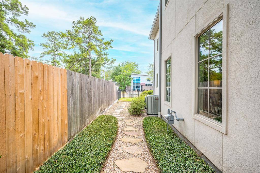 This side yard space with pavers is convenient for access from front of the home to the porch, and could also function as a dog run.