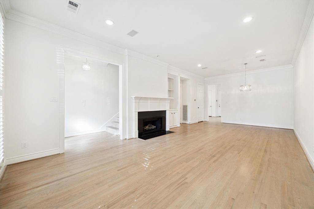 Living / dining area with hardwood flooring, plantation shutters, shelving adjacent to the fireplace. A lot - seriously, a LOT - of storage throughout the townhome.