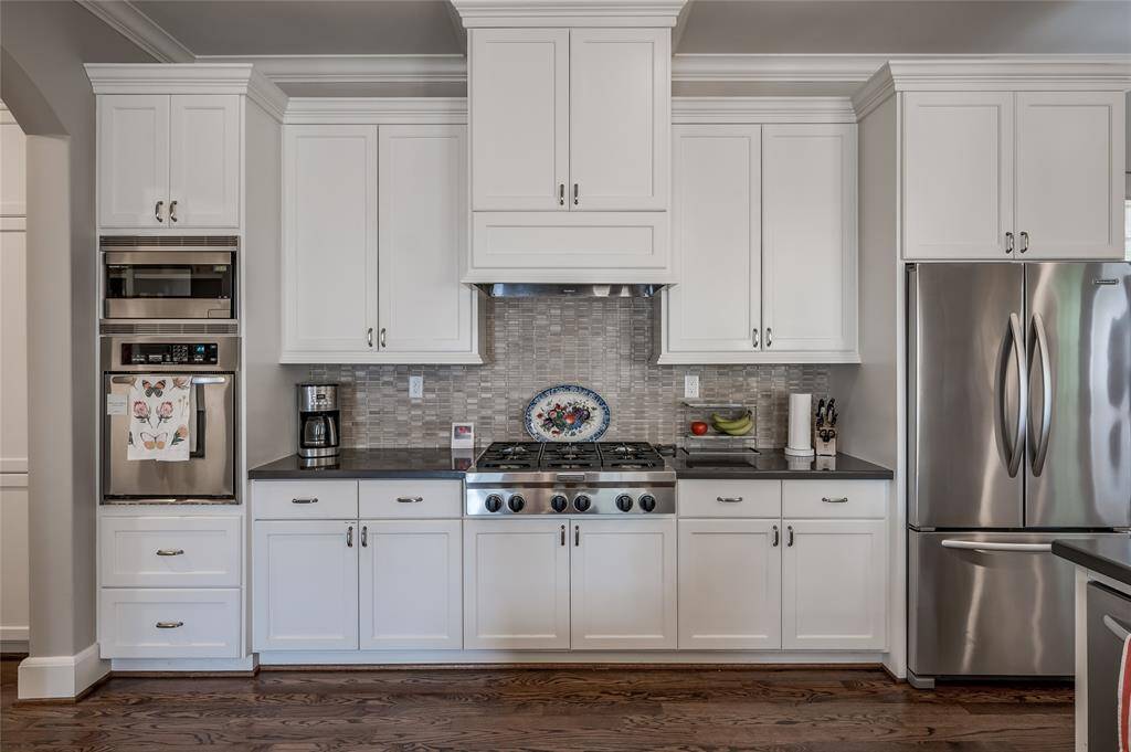 This wonderful kitchen also features a stainless steel gas range, mosaic tile backsplash, plus butlers pantry with built-in desk and access to the garage.