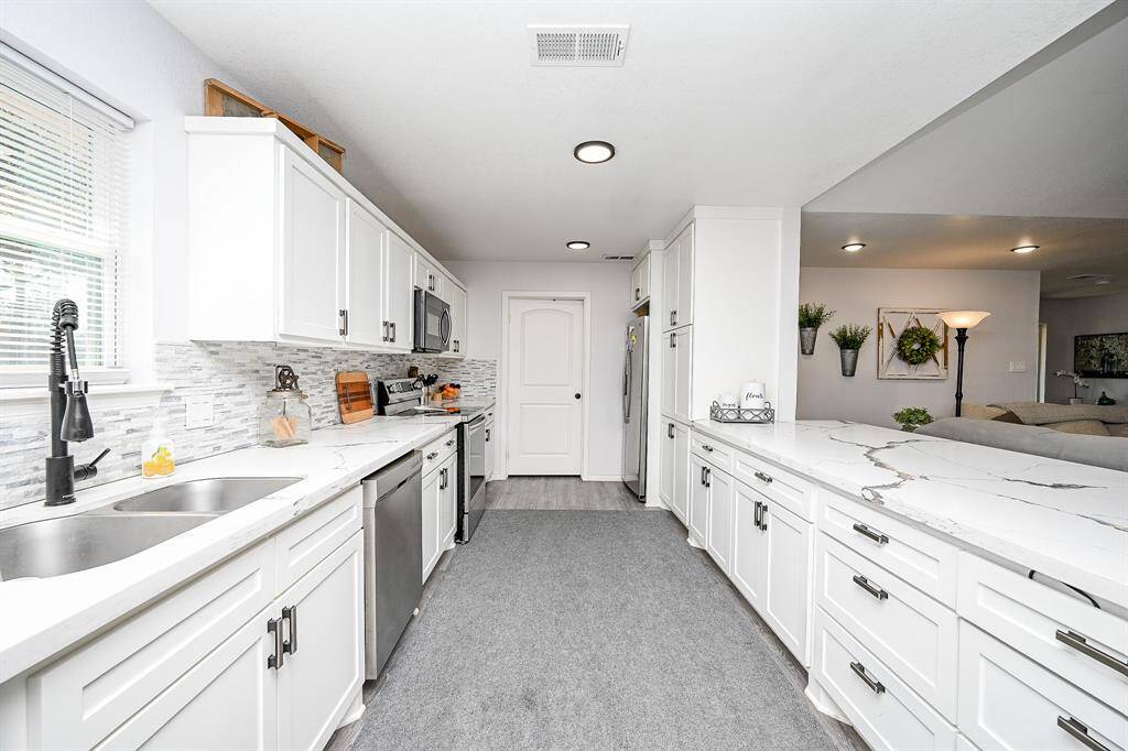 Host your next dinner party with confidence! This fully equipped kitchen features an abundance of cabinetry and hardware, TONS of counter space, quartz countertops and stainless-steel appliances.