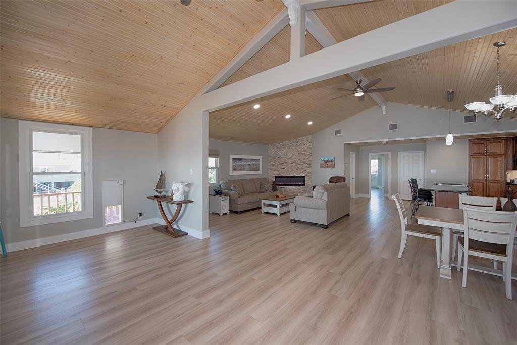 Welcome to your new home, featuring an inviting open concept living area with soaring ceilings and stunning tongue-and-groove wood detailing.