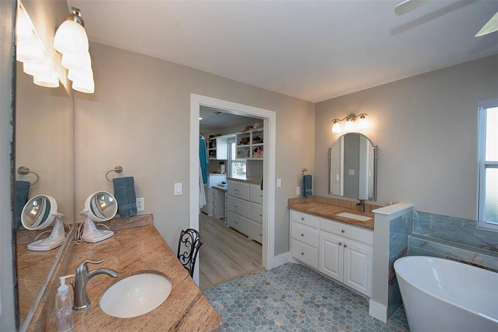 Luxurious en suite bathroom featuring double granite vanities and ample cabinet space.