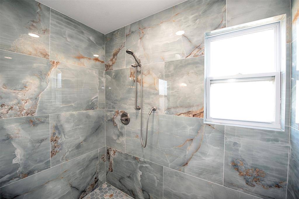 Elegant shower with stunning 2x4 tiles and a convenient sitting area.