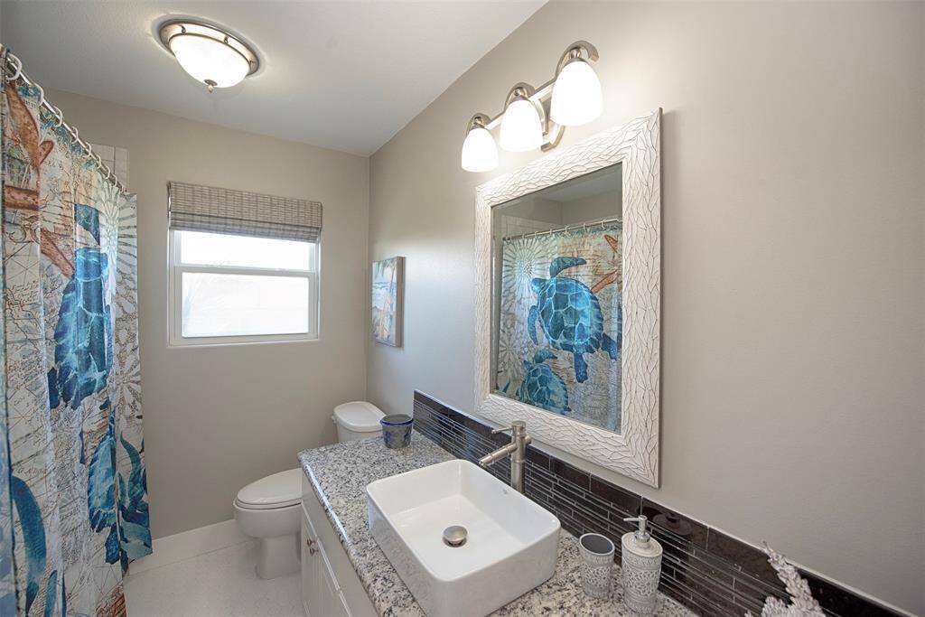 Elegant additional bathroom featuring a granite vanity and modern sink.