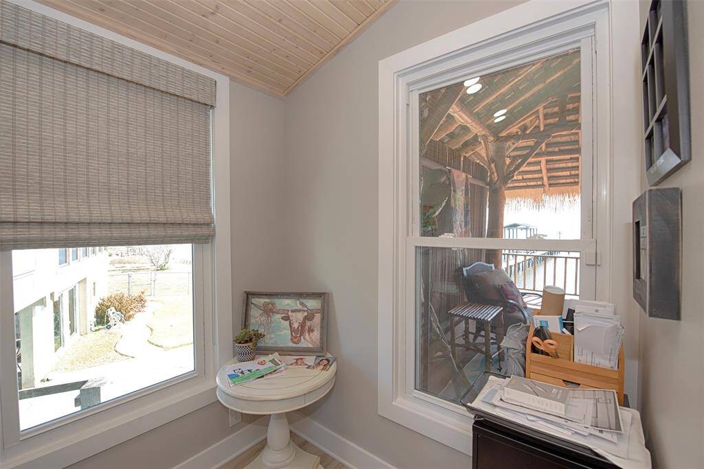 Bright office space featuring dual windows with stunning views of the pool, patio, and bay.