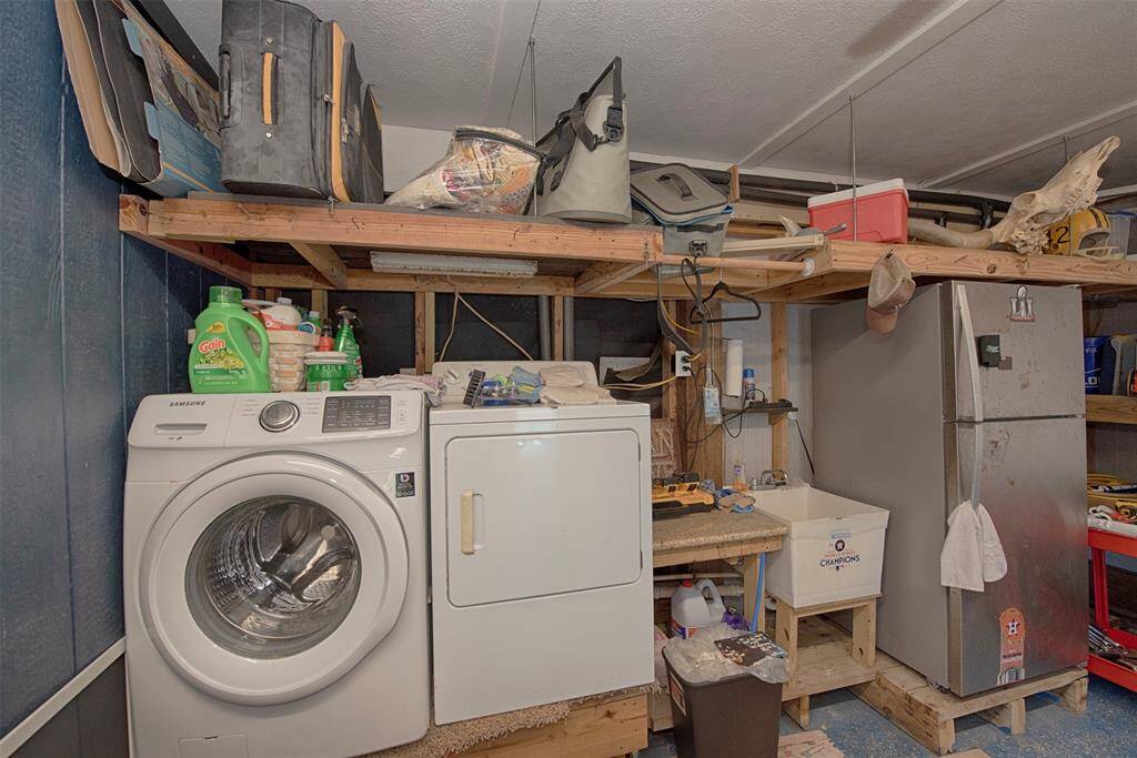 Discover a versatile utility space in the garage, featuring a secondary laundry room with washer and dryer included. The workshop boasts built-in shelving and a utility sink, seamlessly connected to a flexible room. Plus, enjoy the convenience of an RV plug and 50amp plug for generator.