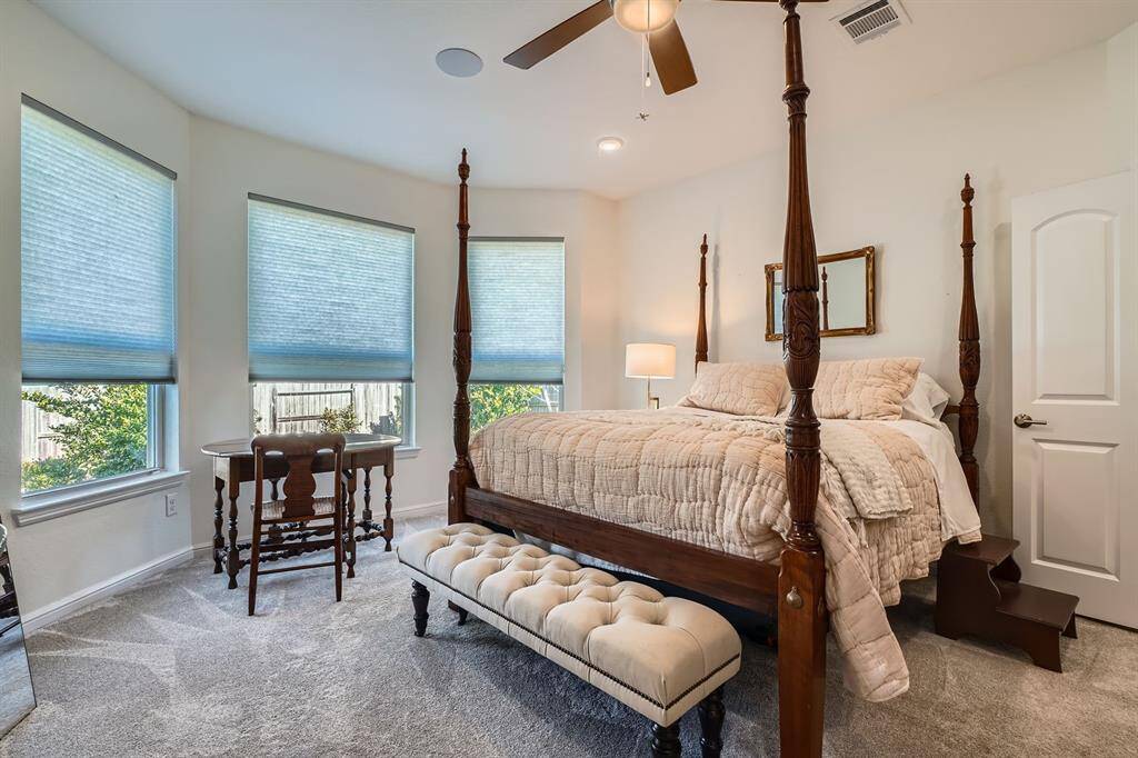 Primary bedroom with high ceilings and large windows