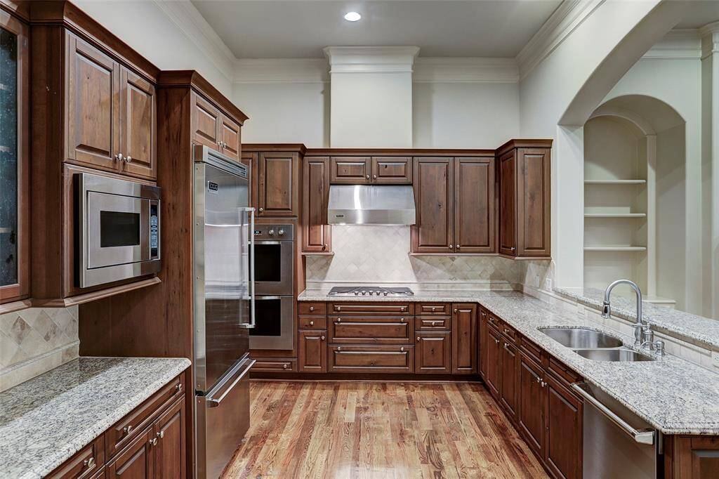 Large kitchen has Viking appliances, 5 burner gas stove, double ovens. updraft vent, large Viking refrigerator, microwave surrounded by Brookhaven cabinets.