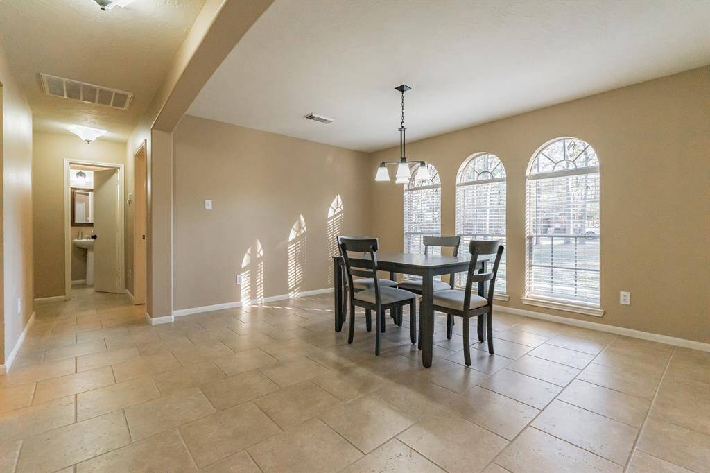 Primary walk-in closet with neutral walls, carpeted floor, and ample shelving for storage.