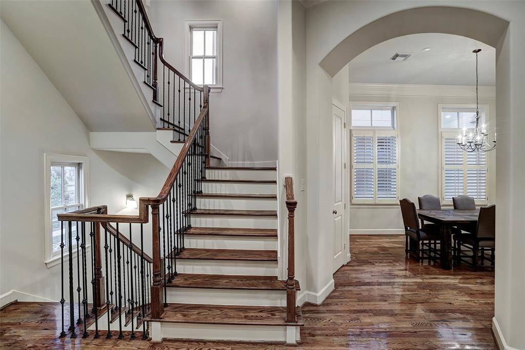 This second floor view shows the formal dining room and gorgeous wrought iron ballusters on the staircase.