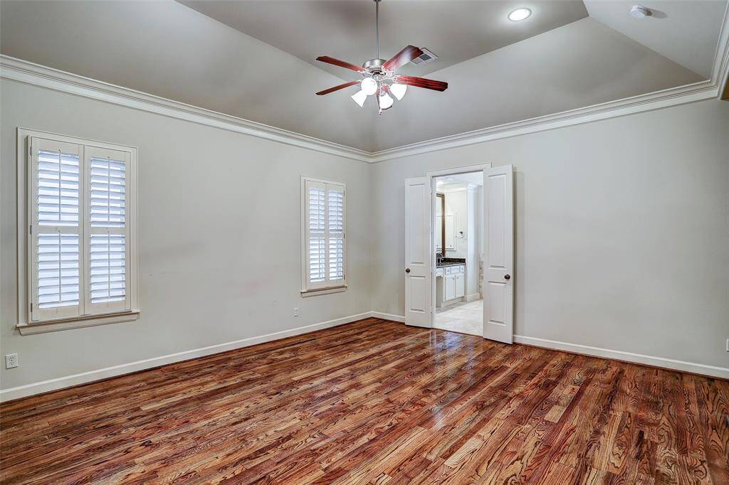 Timeless architecture prevails in the third floor sun-lit master bedroom. Empowered by a coffered ceiling, it has hardwood floors, plantation shutters and multi-piece molding.